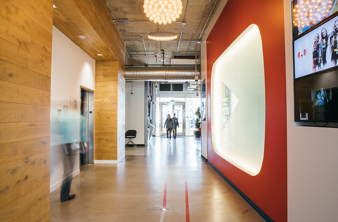 An entryway of the YouTube offices, featuring a large YouTube play button wall installation.